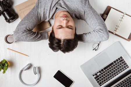 Top view of tired businessman at workplace with copy spaceの写真素材