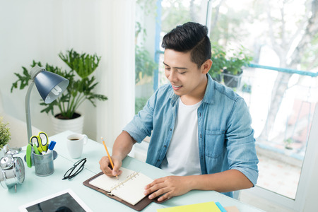 Student doing homework and preparing exam at home.の写真素材