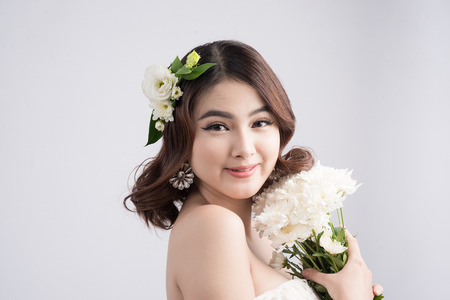 Beautiful asian woman bride on grey background. Closeup portraits with a professional makeupの写真素材