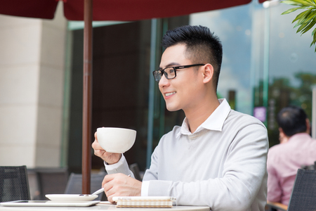 asian smart business man with coffee and newspaper morning time in coffeeshopの写真素材