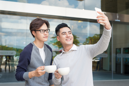 Two young man video call using smartphoneの写真素材