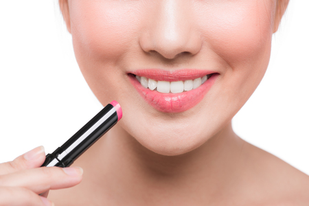 Pretty face beauty lady applying lipstick. Beautiful girl makes makeupの写真素材