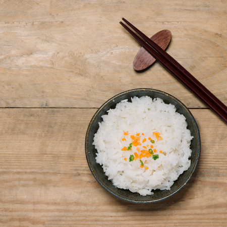 Close up of cooked rice in wooden in bowl on wooden tableの写真素材