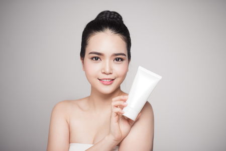 Beauty concept. Asian pretty woman with perfect skin holding cosmetic bottleの写真素材