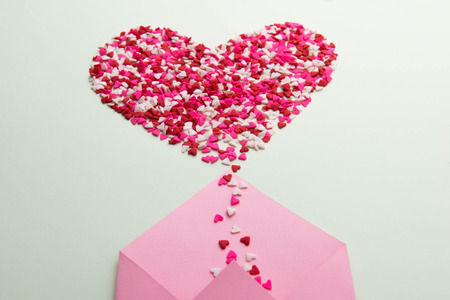 Sweets sugar candy hearts on envelope over green backgroundの写真素材