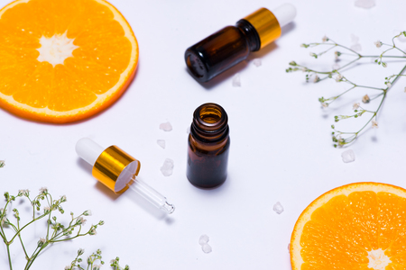 Branding mock-up. Natural essential oil, Cosmetic bottle containers with orange slices.の写真素材