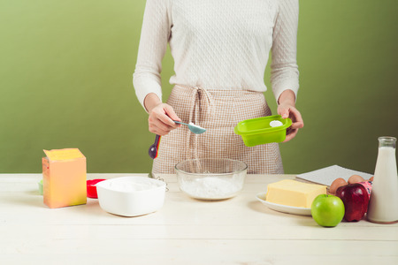 House wife wearing apron making. Steps of making cooking apple cake. Cutting green apple.の写真素材