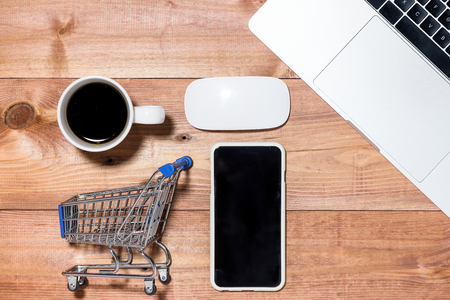 Trolley, keyboard, mobile and credit cards for online purchasing on stone background top view mockupの写真素材