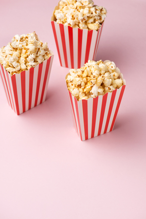 Popcorn in red and white cardboard box on the pink background.の写真素材