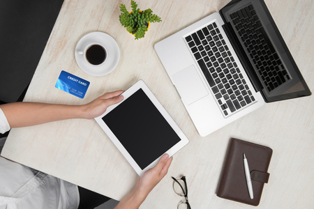 Top view of man using a digital tablet in office shopping with credit cardの写真素材