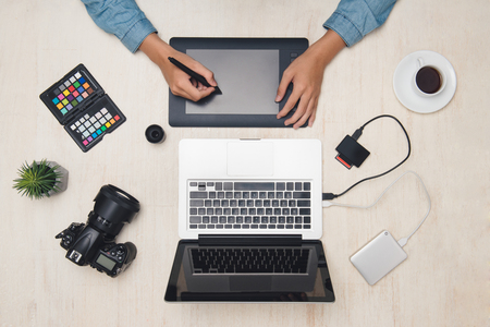 Male graphic designer working with tablet at desk.の写真素材