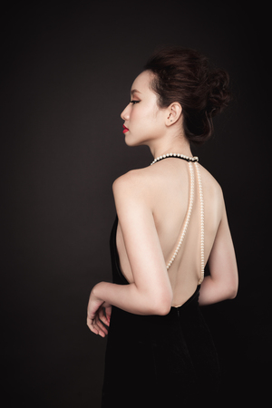 Beautiful woman portrait on black background. Young lady posing with gorgeous make up and hairstyle.の写真素材