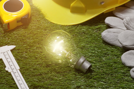 Green building and energy saving concept: house projecj and work tools on the grassの写真素材