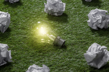 great concept with crumpled office paper and light bulb standing on the tableの写真素材