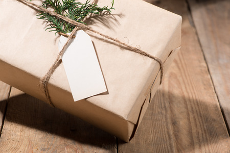 Kraft paper box and green leaves on woodean background.の写真素材
