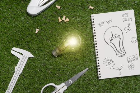 Green building and energy saving concept: house projecj and work tools on the grassの写真素材