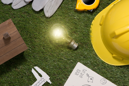 Green building and energy saving concept: house projecj and work tools on the grassの写真素材