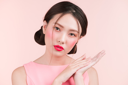 Beauty portrait of female asian face over pink color background. Studio shot.の写真素材
