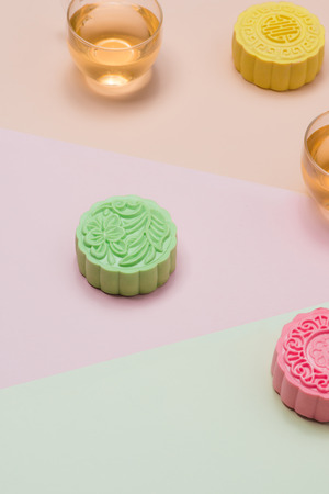 Sweet color of snow skin mooncake. Traditional mid autumn festival foods with tea on table setting.の写真素材