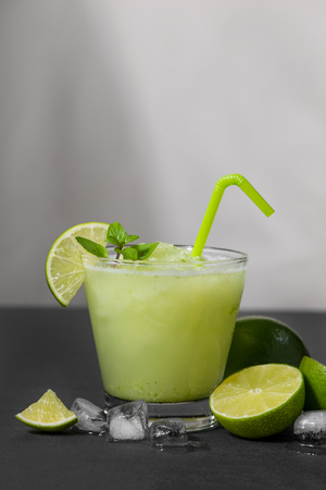 Cocktail juice with lime, mint and ice. Bar drink accessories on black table background.の写真素材