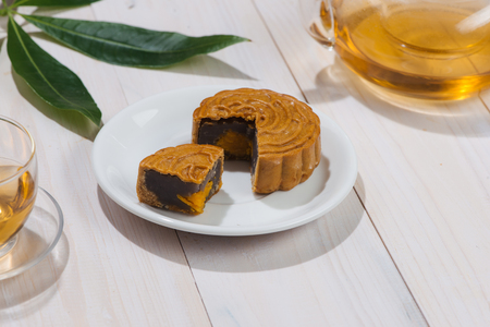Retro vintage style Chinese mid autumn festival foods. Traditional mooncakes on table settingの写真素材