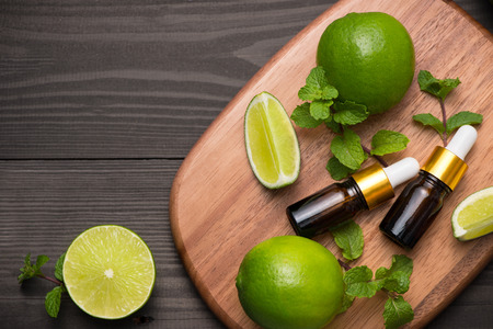 Natural cosmetics for home spa. Bottle of essence oil with fresh limesの写真素材