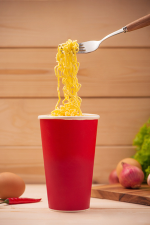 Eating Instant noodles in cup with a forkの写真素材