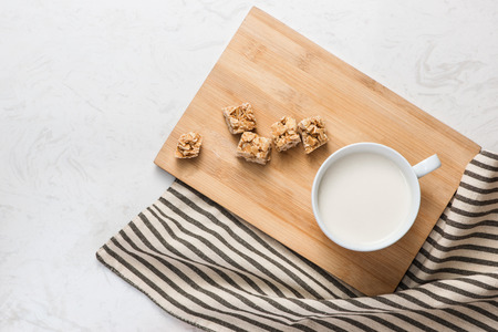Dairy products. A cup of milk serve with almond candies on a rustic wooden table.の写真素材