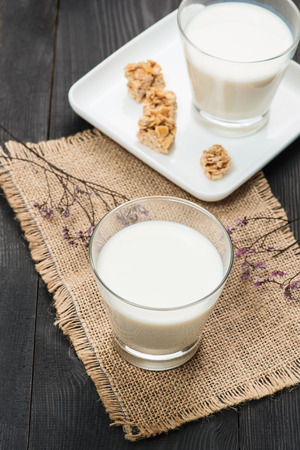 Dairy products. A glass of milk serve with almond candies on a rustic wooden table.の写真素材