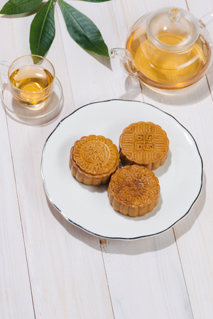 Retro vintage style Chinese mid autumn festival foods. Traditional mooncakes on table settingの写真素材