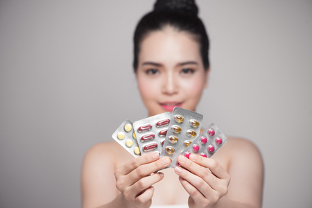 Healthy happy asian woman with pills in hand.の写真素材
