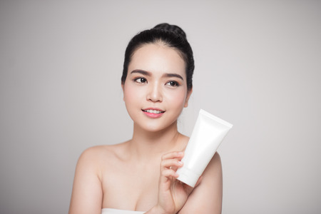 Beauty concept. Asian pretty woman with perfect skin holding cosmetic bottleの写真素材