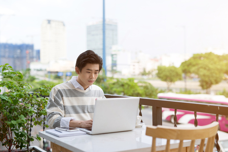 Asian young business man working with laptop at the city cafe.の写真素材