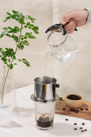 Coffee dripping in vietnamese style on wooden tableの写真素材