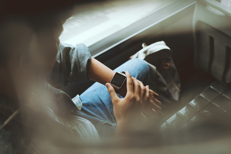 Handsome asian man sitting in city bus and wearing smart watchの写真素材