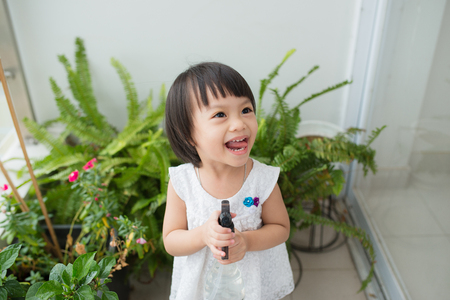 Child taking care of plants. Cute little girl watering first spring flowersの写真素材