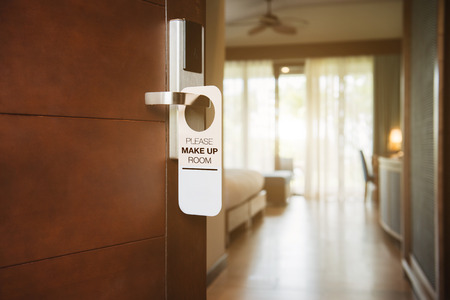 The hotel room with PLEASE MAKE UP ROOM sign on the doorの写真素材
