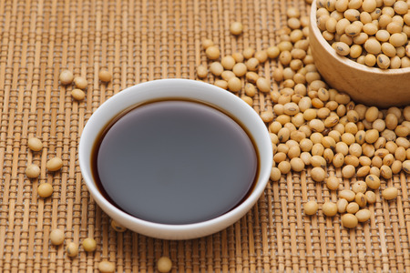 Soy sauce and soy bean on wooden tableの写真素材