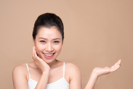Proposing a product. Beautiful spa woman showing empty copy space on the open hand palmの写真素材