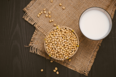 Glass with soy milk and soy bean on wooden backgroundの写真素材