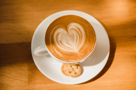 Cup of cappuccino with foam in the form of heartの写真素材