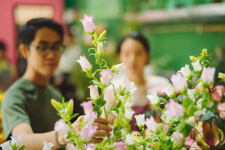 Florist guiding male customer in buying flowers at storeの写真素材