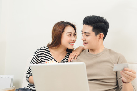 Young asian couple payment online using laptop and credit cardの写真素材