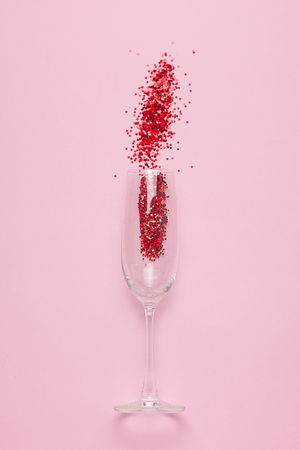 Flat lay of Celebration. Champagne glass with colorful party streamers on pink background.の写真素材
