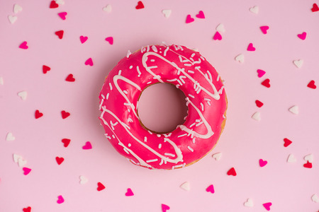 Donuts with icing on pastel pink background with copyspace. Sweet donuts.の写真素材