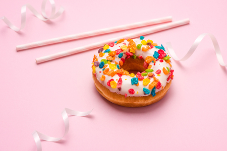 Delicious donuts for birthday on pastel pink background.の写真素材