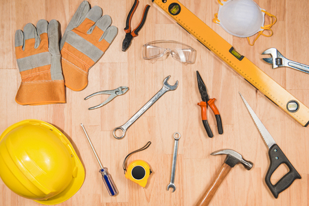 Construction safety helmet and tools supplies on wooden deskの写真素材