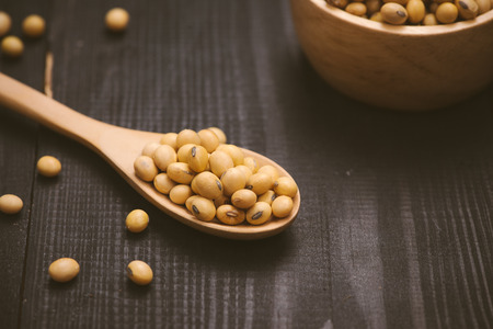 Soy beans in spoon on wooden backgroundの写真素材