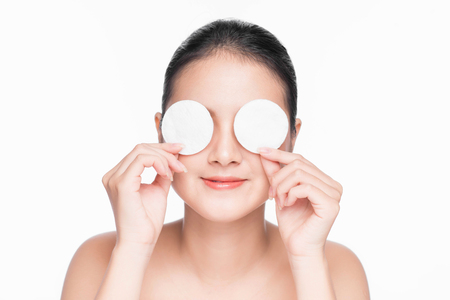 Young asian girl cares for face skin relaxation using cotton pad.の写真素材