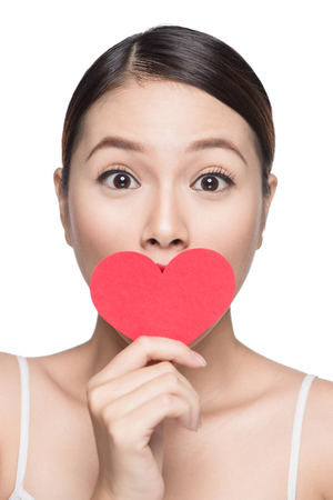 Attractive young asian woman holding red heart. Valentine's day art portrait. Perfect make upの写真素材